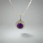 front of diamond and amethyst necklace with 1 large round amethyst purple gemstone in center and 2 rows of diamonds around amethyst