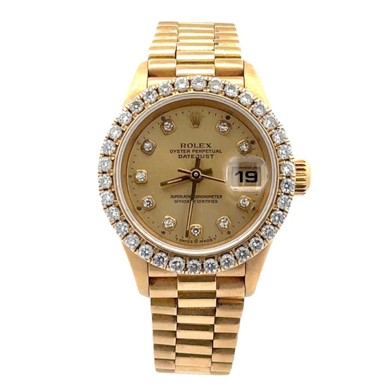 Gold watch with diamond-studded bezel on a white background