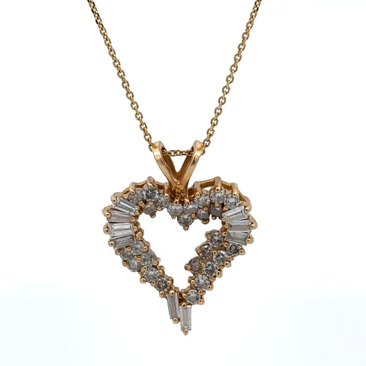 Heart-shaped diamond pendant on a gold chain against a white background