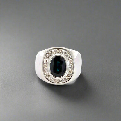 Front of white gold dome shaped ring with 1 dark blue oval-shaped Sapphire in center and  18 round diamonds surrounding it. Shows scratches on gold 