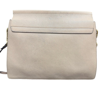 A light beige leather shoulder bag with a flap closure and gold-tone hardware, shown against a plain white background.
