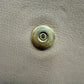 Close up of gold hardware button with scratches and discoloration