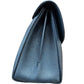 A close-up side view of the black bag showing the pebbled grain and a central seam, set against a plain white background.