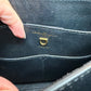 Close-up of the interior of a black leather handbag showing the gold-tone Salvatore Ferragamo signature ring hardware and embossed brand name.