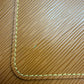 Close-up of a brown textured leather corner with light yellow stitching with a small light green-colored stain
