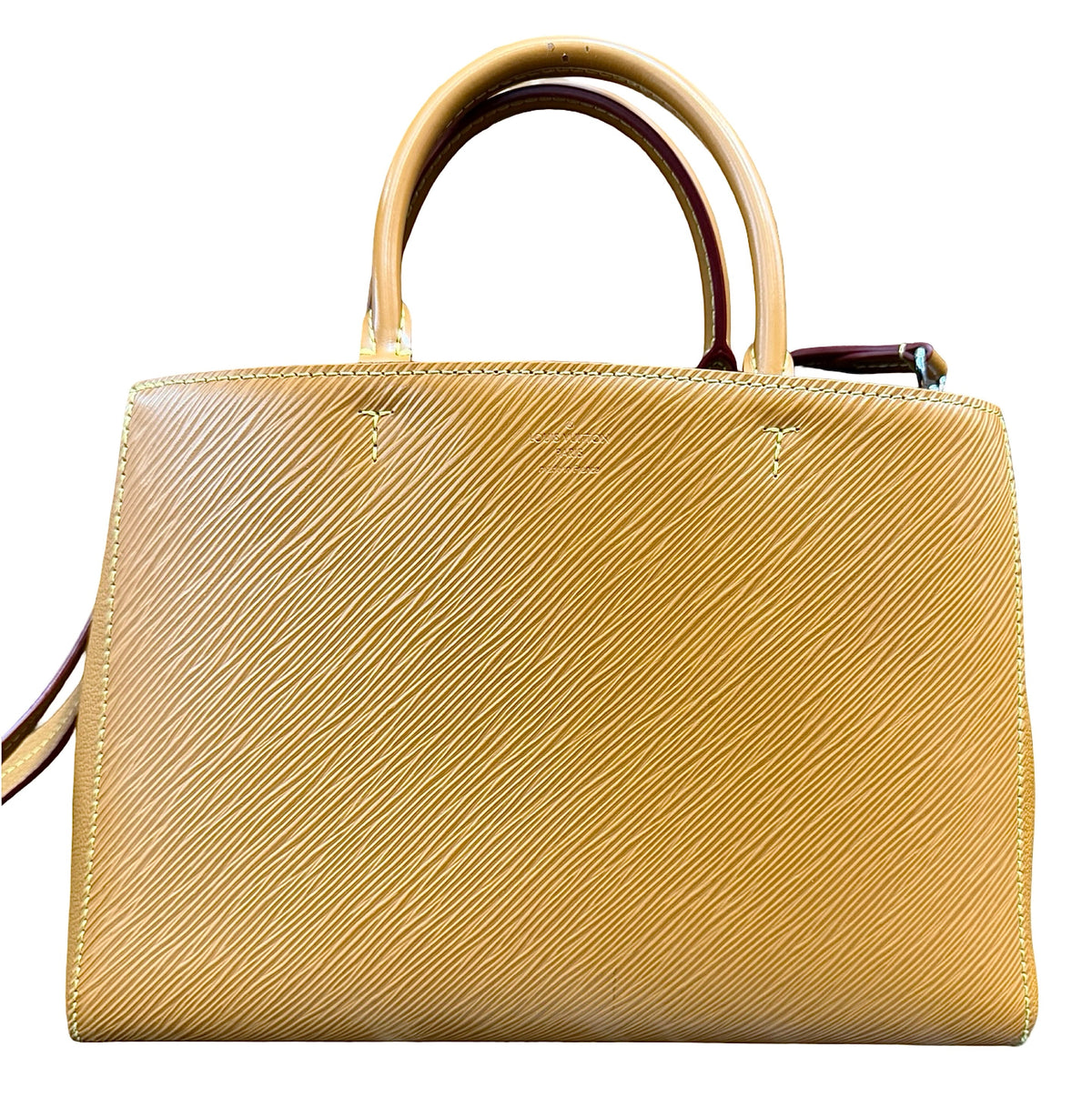 A structured brown leather handbag with a textured diagonal grain pattern, featuring two top handles and a shoulder strap, shown against a plain white background.