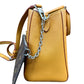 A brown epi leather handbag shown from the side, featuring a silver chain detail and a dark brown monogram pouch attached, set against a plain white background.
