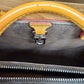 Close-up of handbag showing the interior lining, silver zipper, and a brown leather handle with chips in the leather