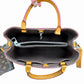 An open Louis Vuitton handbag shown from the inside, with a hand holding the top handle. The bag has brown leather handles and trim, a dark brown interior, and silver-tone hardware.