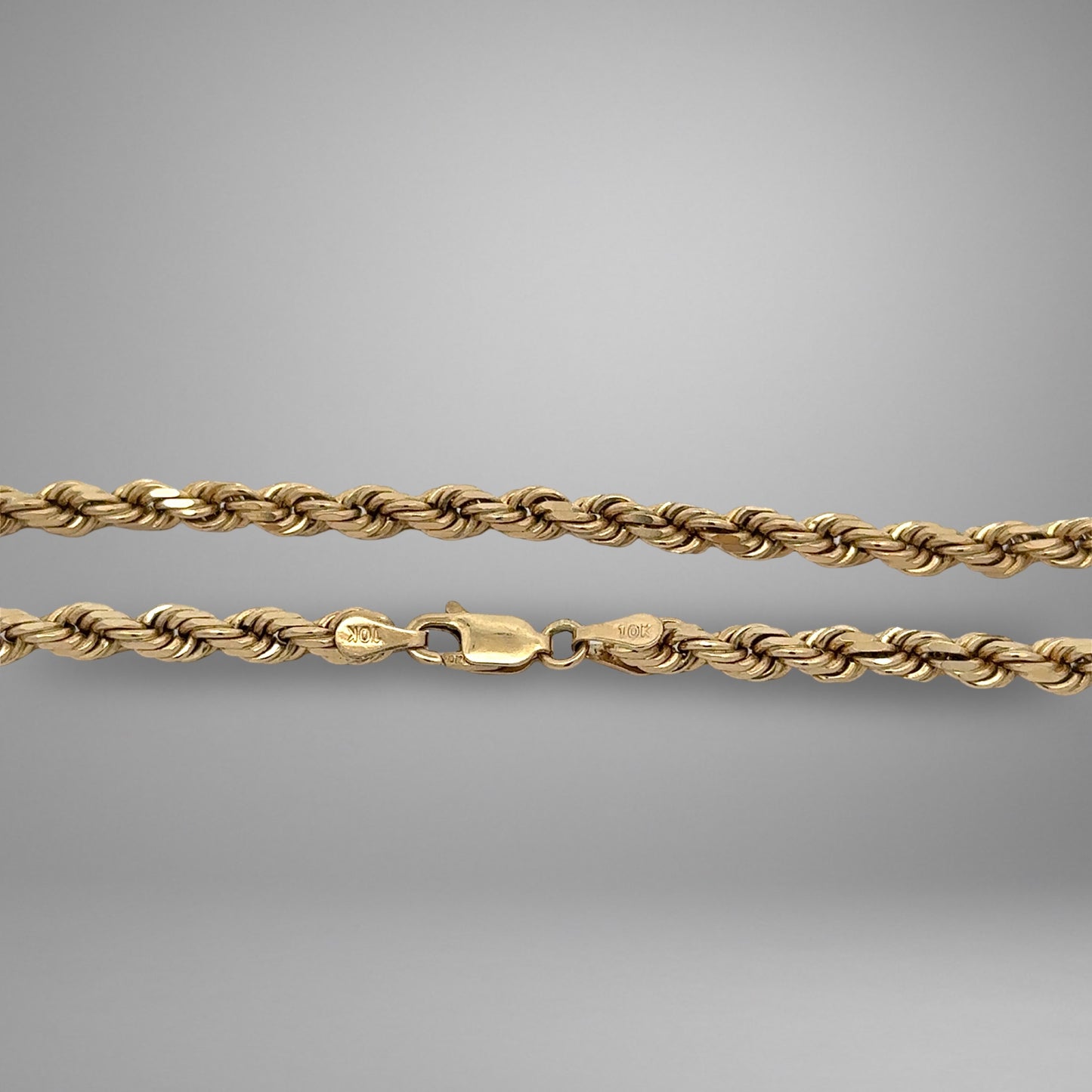 Gold rope chain on a gray background