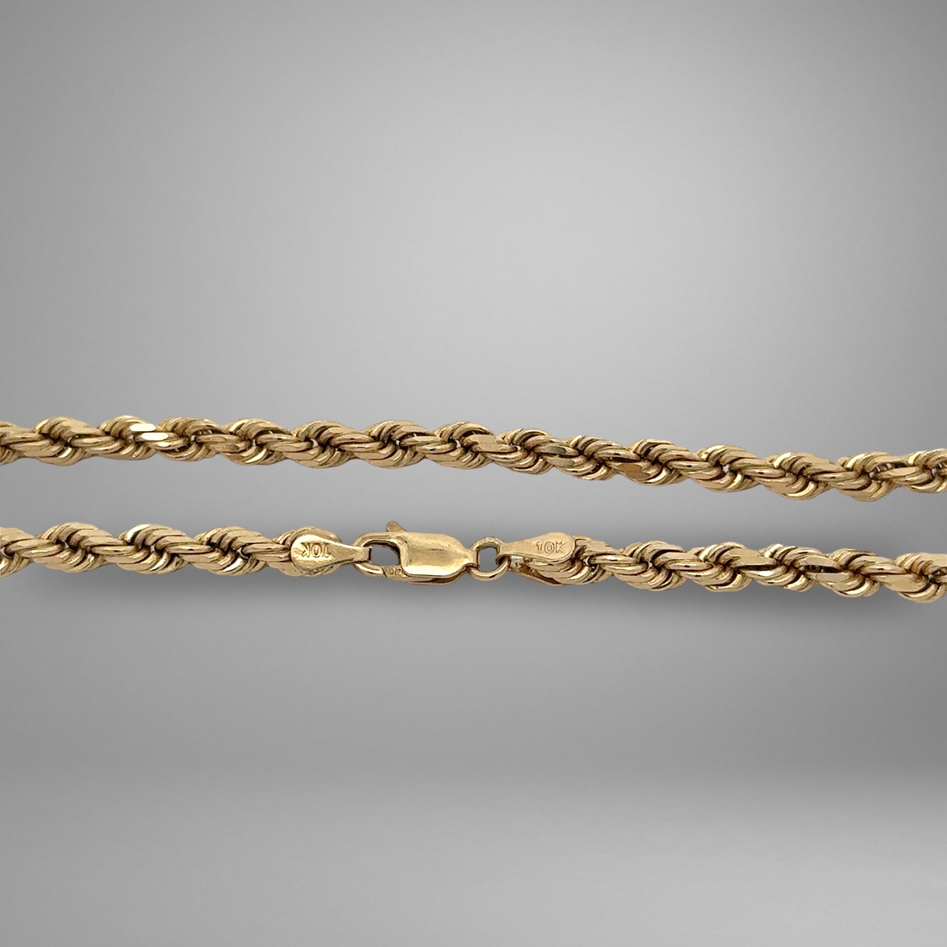 Gold rope chain on a gray background
