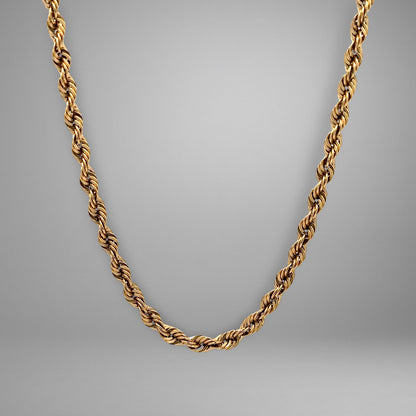 Gold chain necklace on a gray background