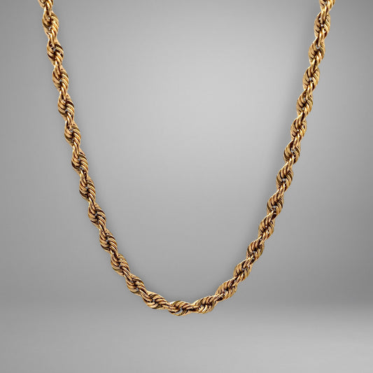 Gold chain necklace on a gray background