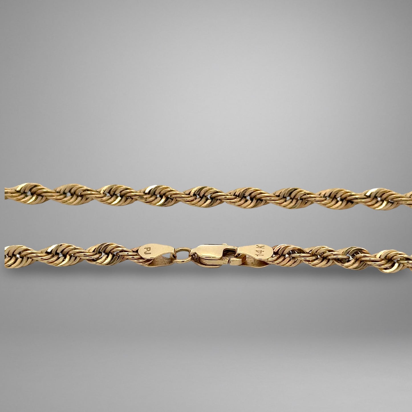Gold rope chain on a gray background