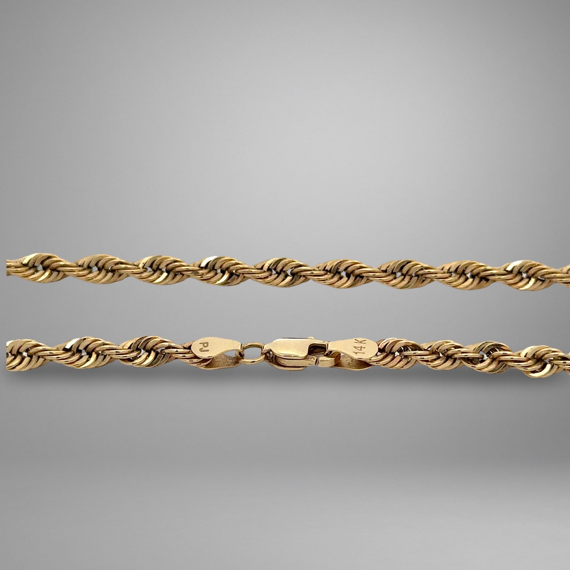 Gold rope chain on a gray background