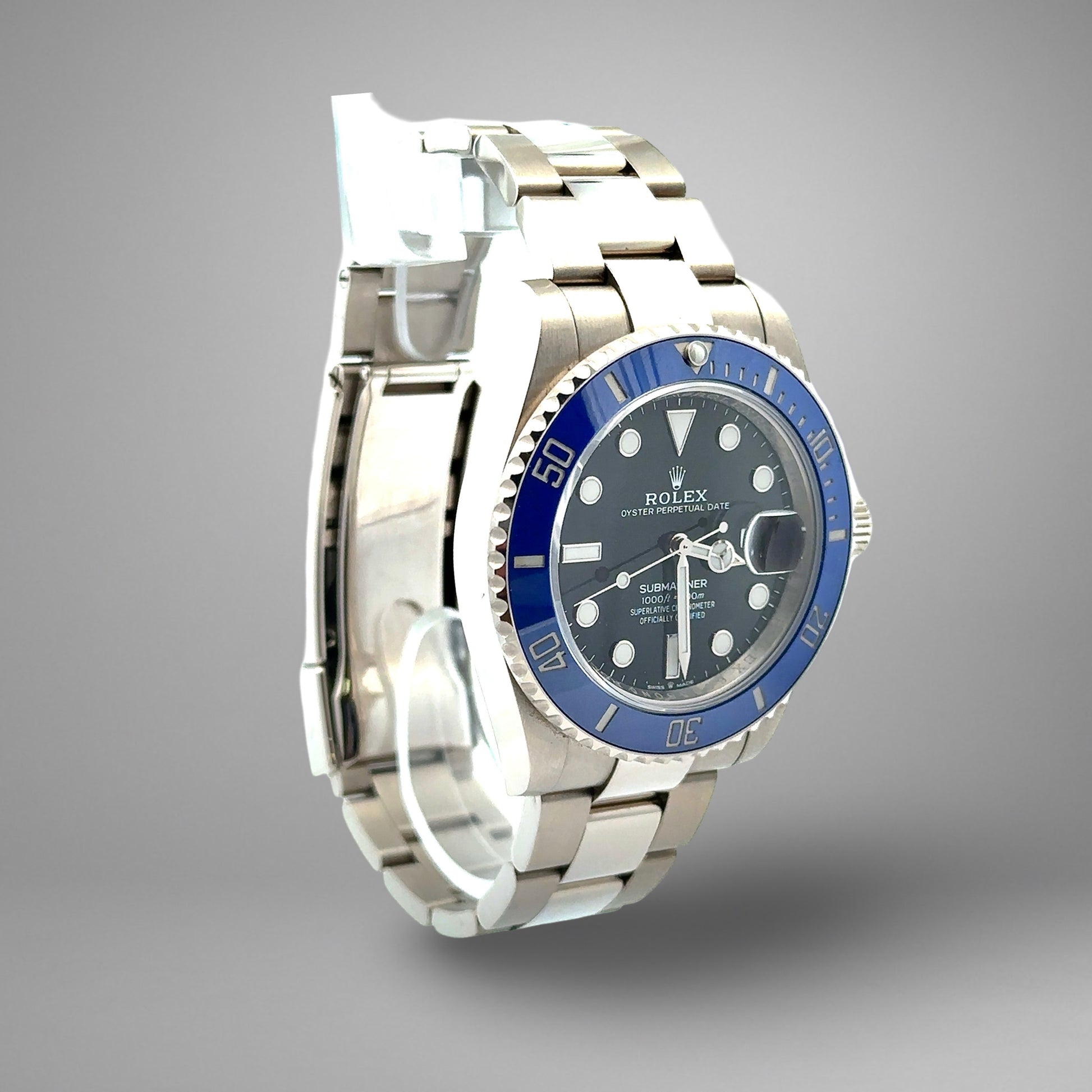 Silver watch with blue bezel and black face on a gray background