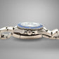 Silver watch with a blue bezel on a gray background