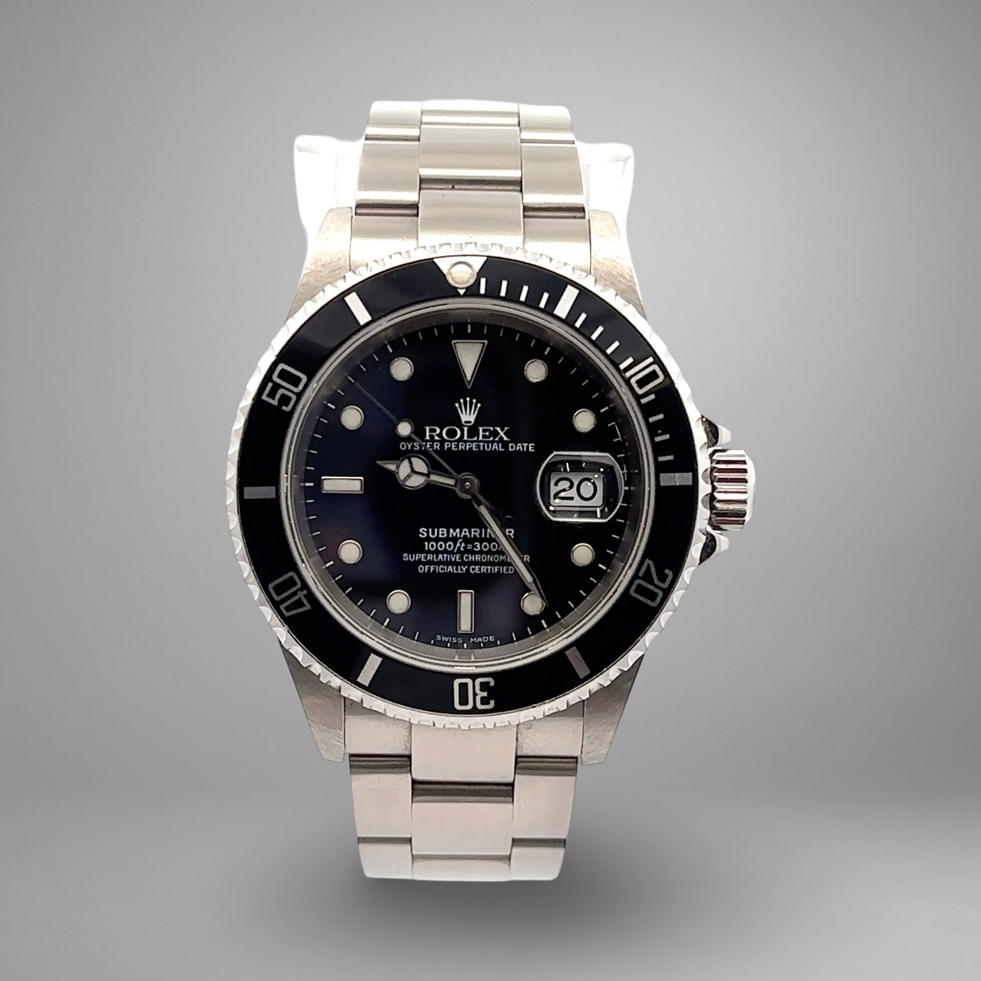 Silver Rolex watch with black dial on a gray background