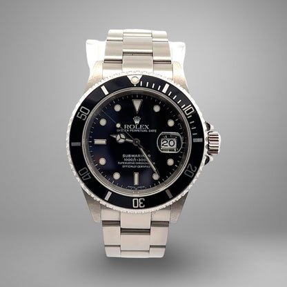 Silver Rolex watch with black dial on a gray background