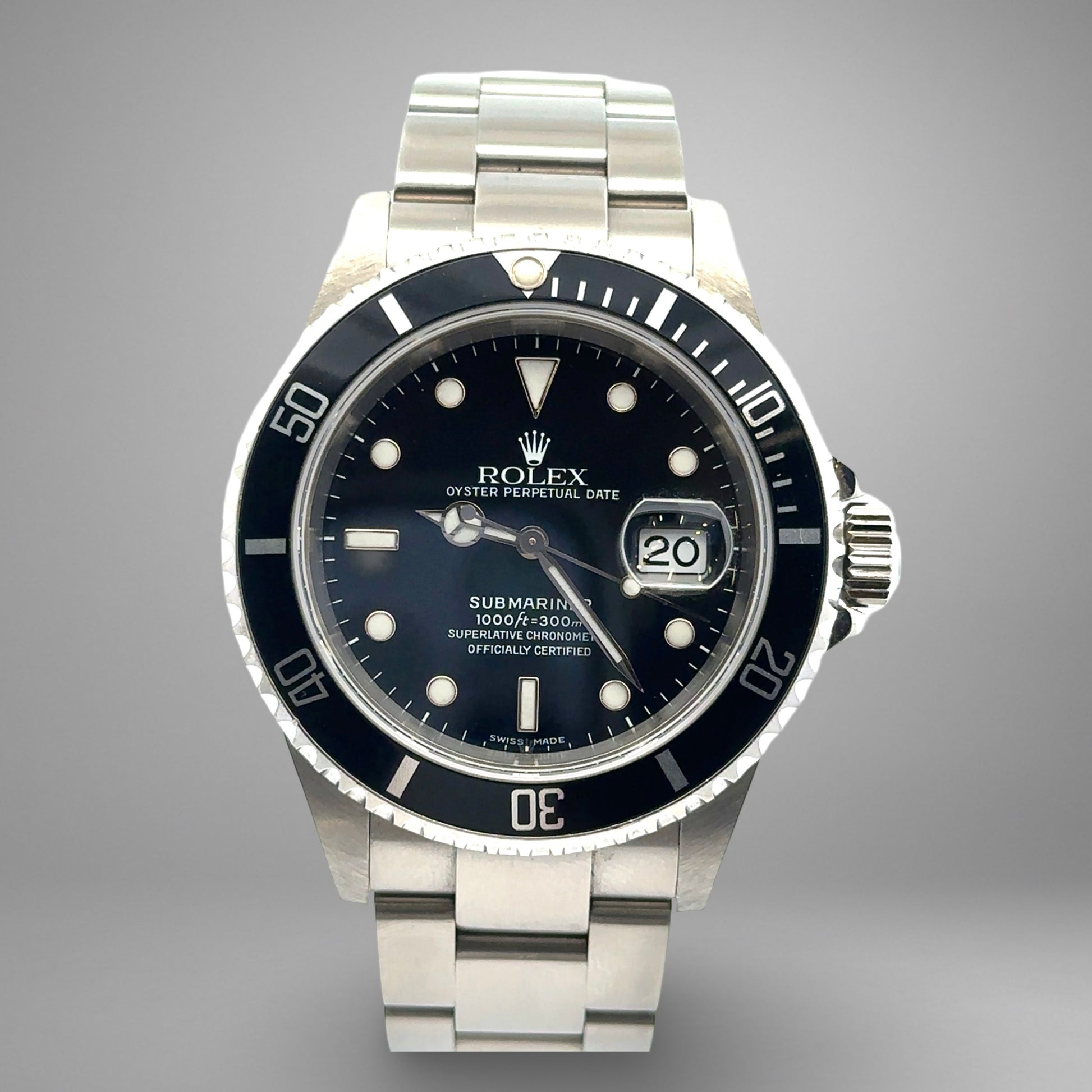 Rolex Submariner watch with black dial and silver metal bracelet on a gray background