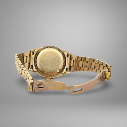 Gold wristwatch on a gray background