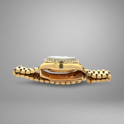 Gold watch with a textured band on a gray background