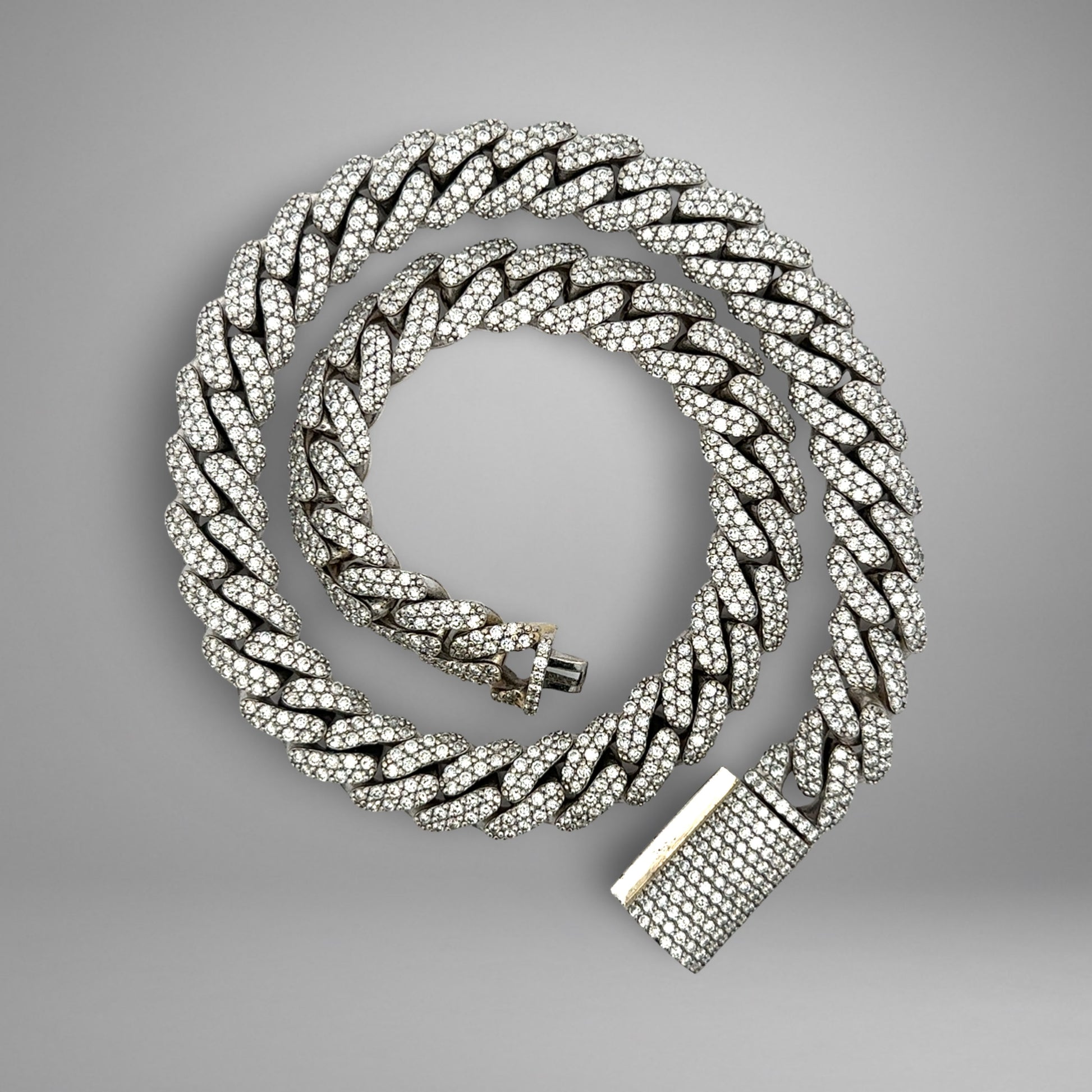 Silver chain necklace with a clasp on a gray background
