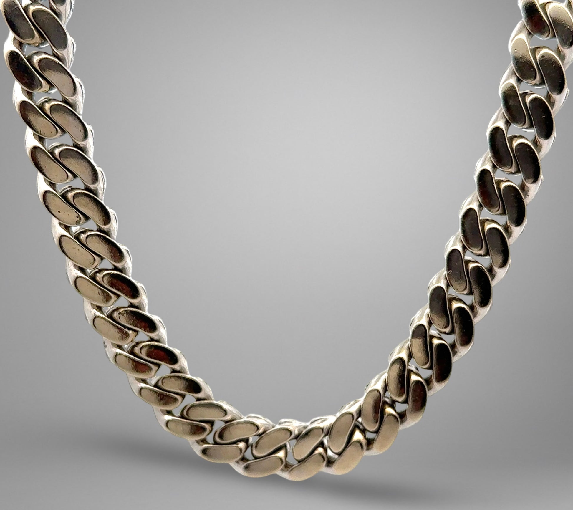 Silver chain necklace on a gray background