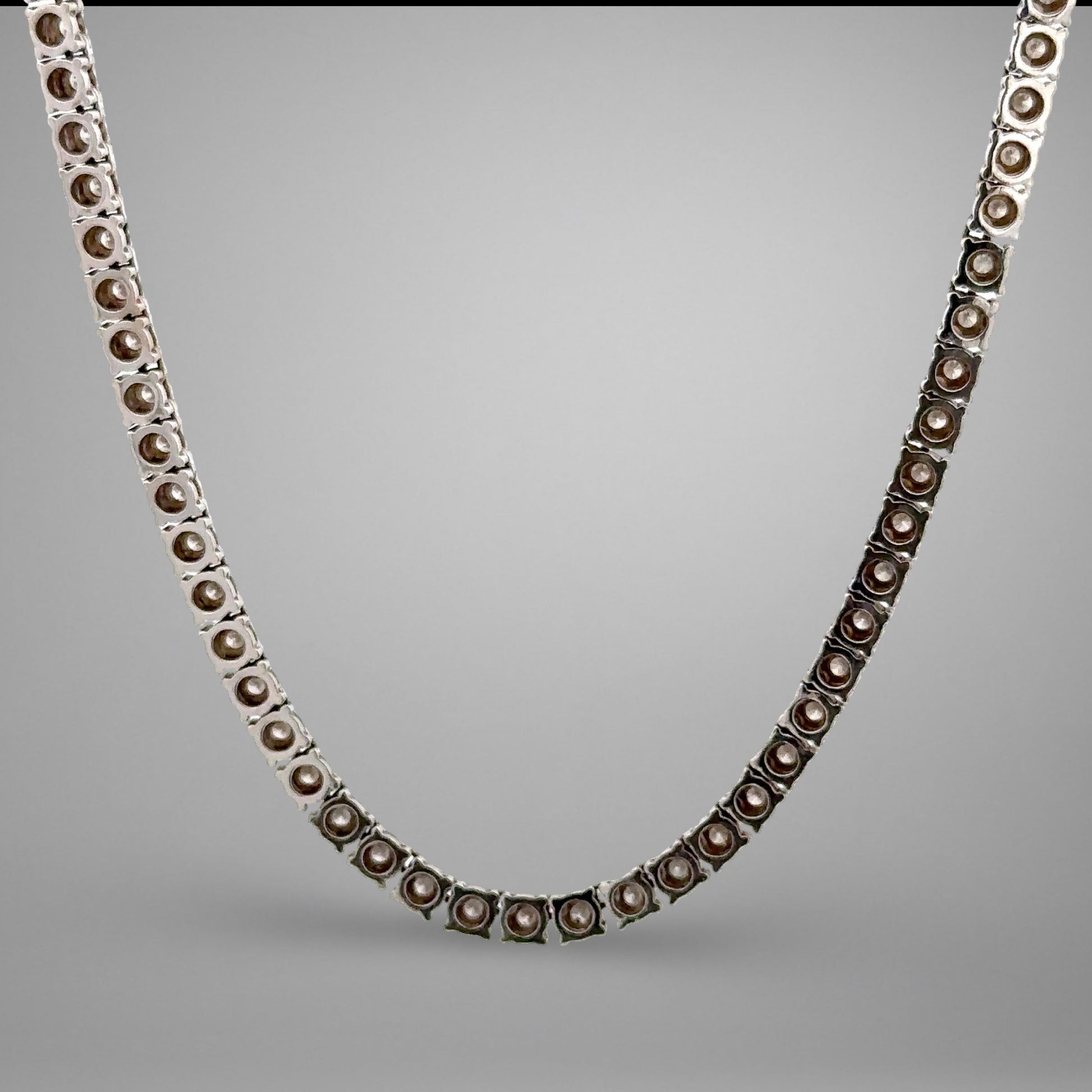Silver necklace with brown beads on a gray background