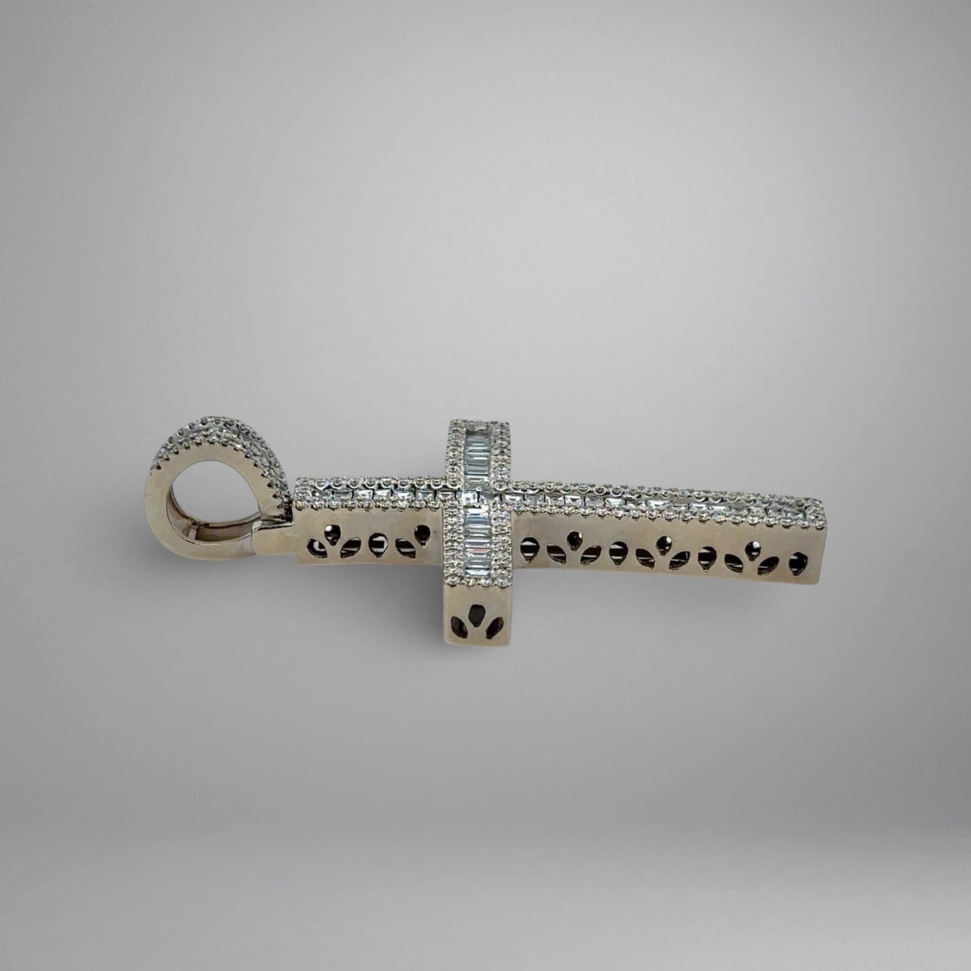 Silver cross pendant with diamonds on a gray background
