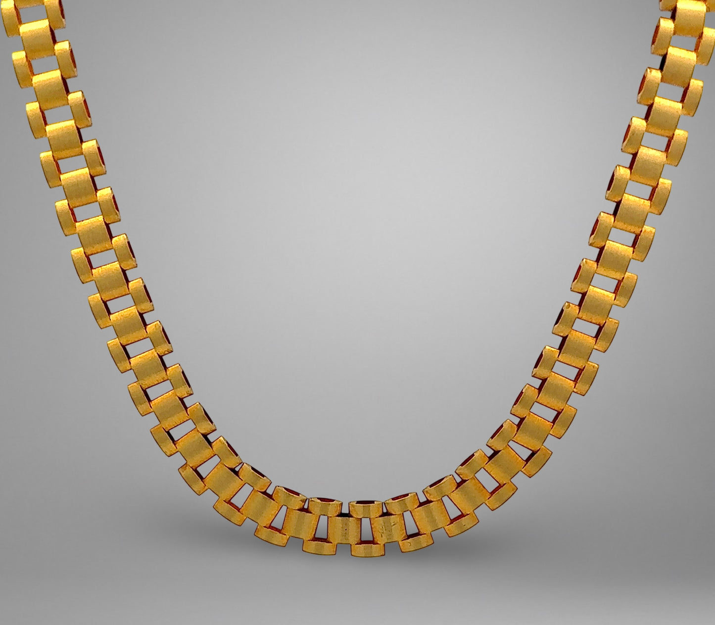 Gold necklace on a gray background