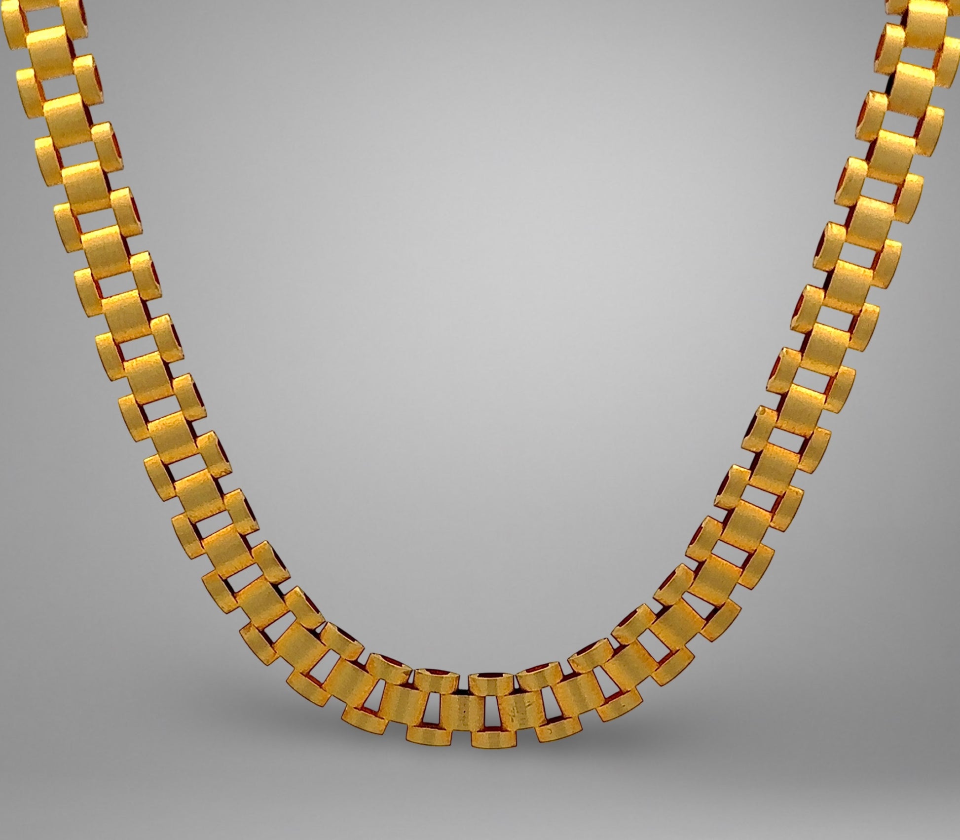 Gold necklace on a gray background