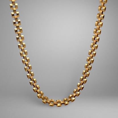 Gold chain necklace on a gray background
