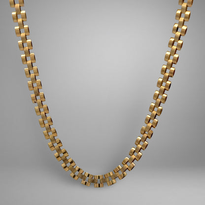 Gold chain necklace on a gray background