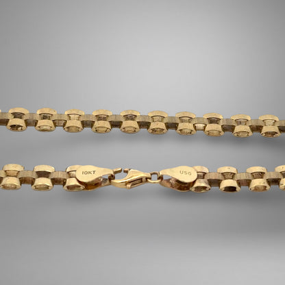 Gold chain with clasp on a gray background