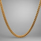 Gold chain necklace on a gray background