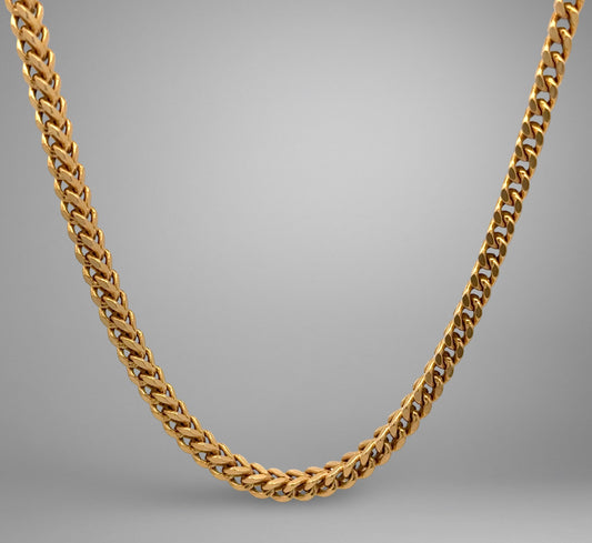 Gold chain necklace on a gray background