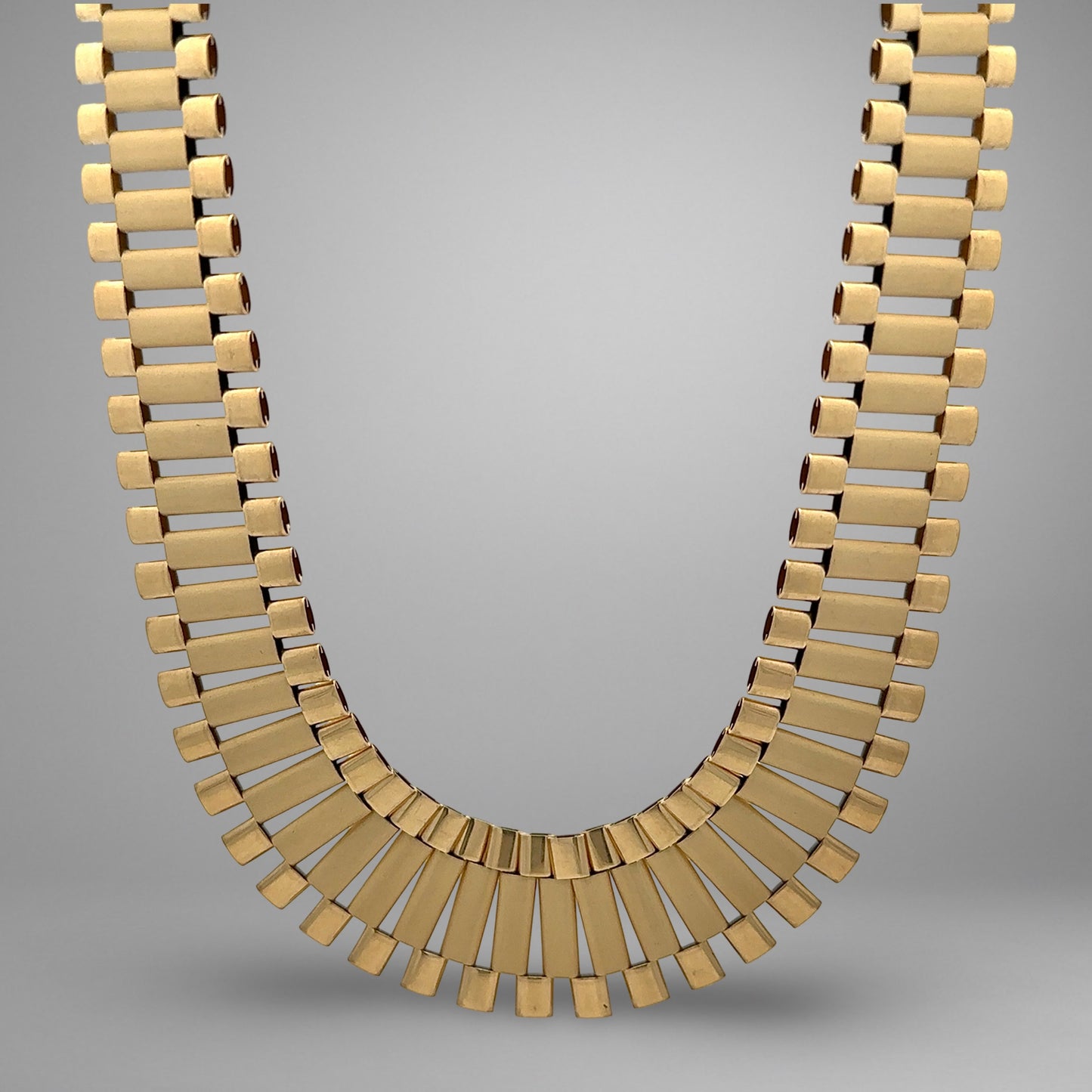 Gold necklace on a gray background