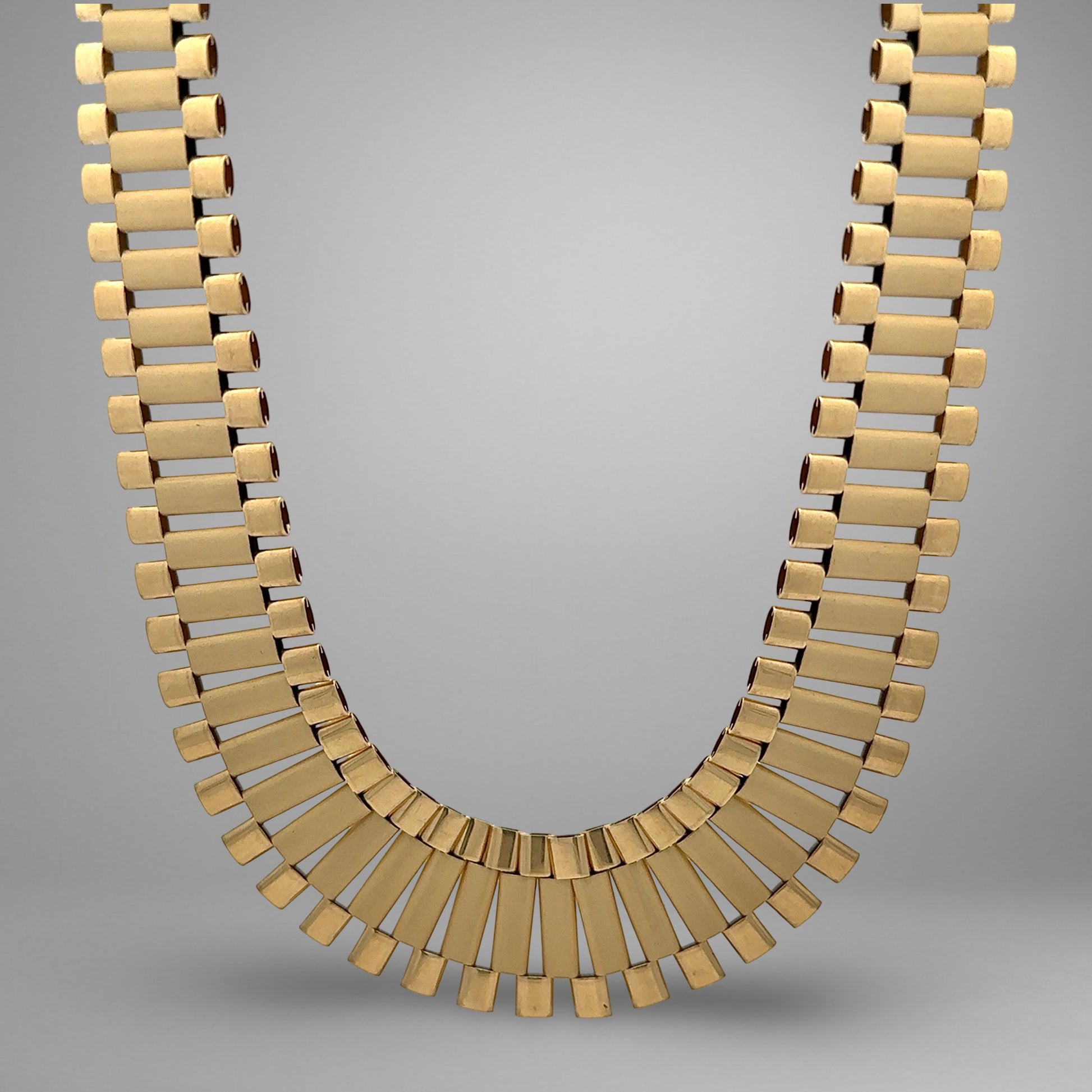 Gold necklace on a gray background