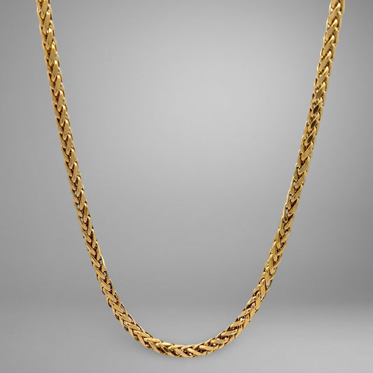 Gold chain necklace on a gray background