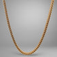 Gold chain necklace on a gray background