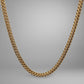 Gold chain necklace on a gray background