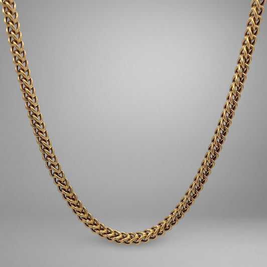 Gold chain necklace on a gray background