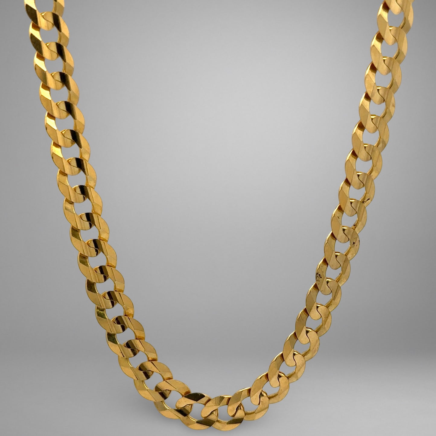 Gold chain necklace on a gray background