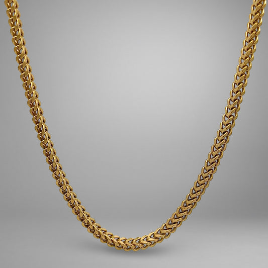 Gold chain necklace on a gray background