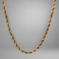 Gold rope chain necklace on a gray background