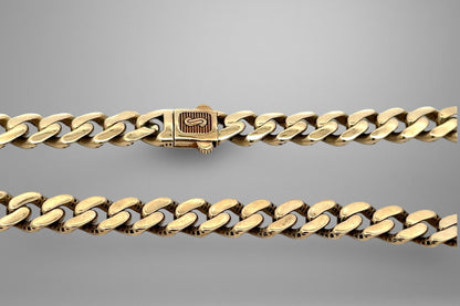 Gold chain bracelet on a gray background