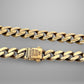 Gold chain bracelet on a gray background