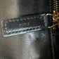 Close up of zipper with Paris embossed in black leather and gold hardware