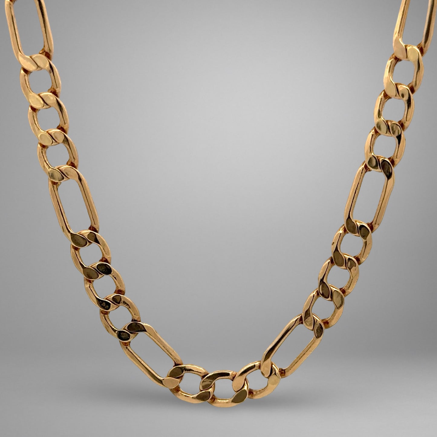 Gold chain necklace on a gray background